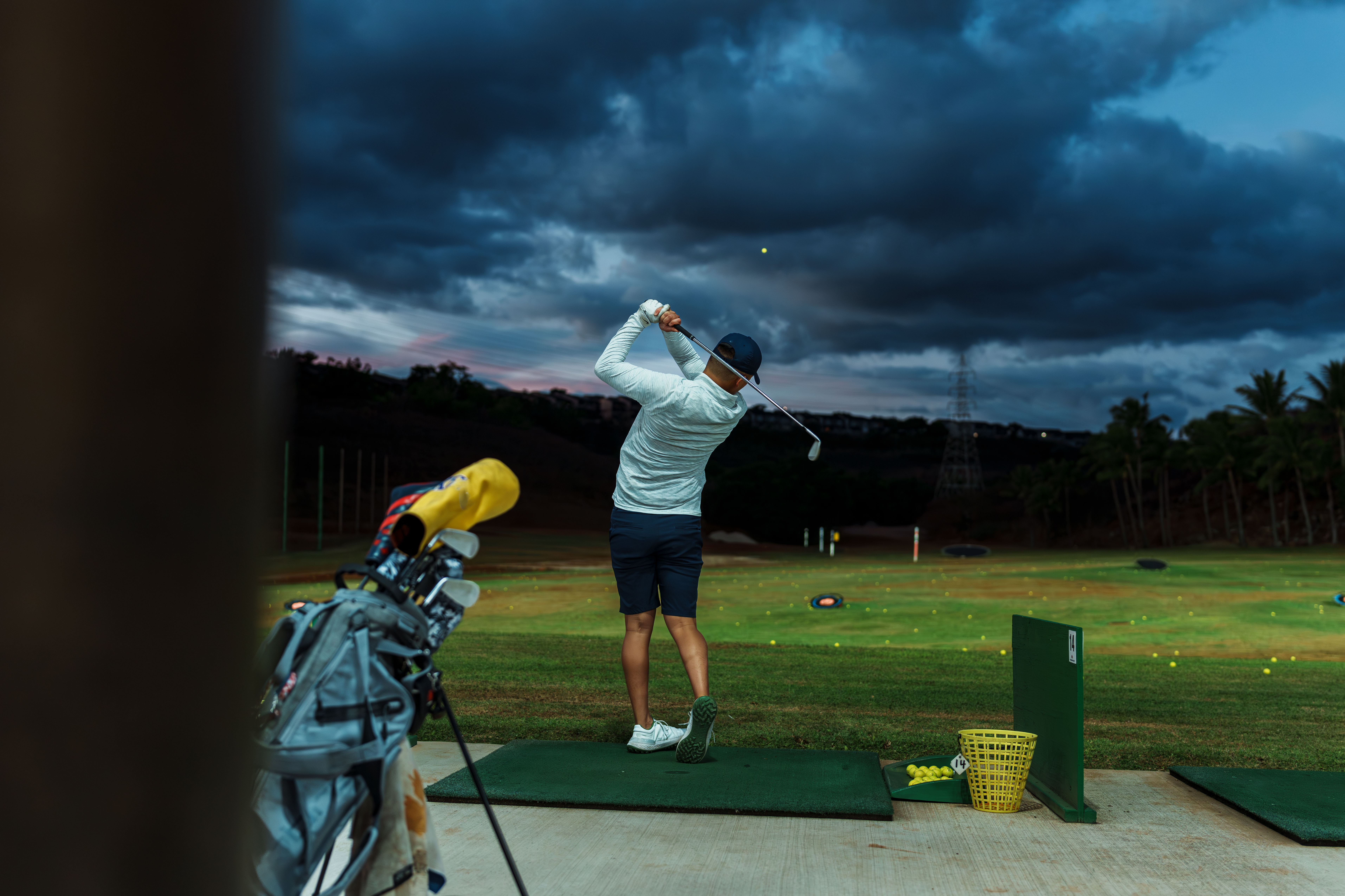A golfer hits a golf ball on the range