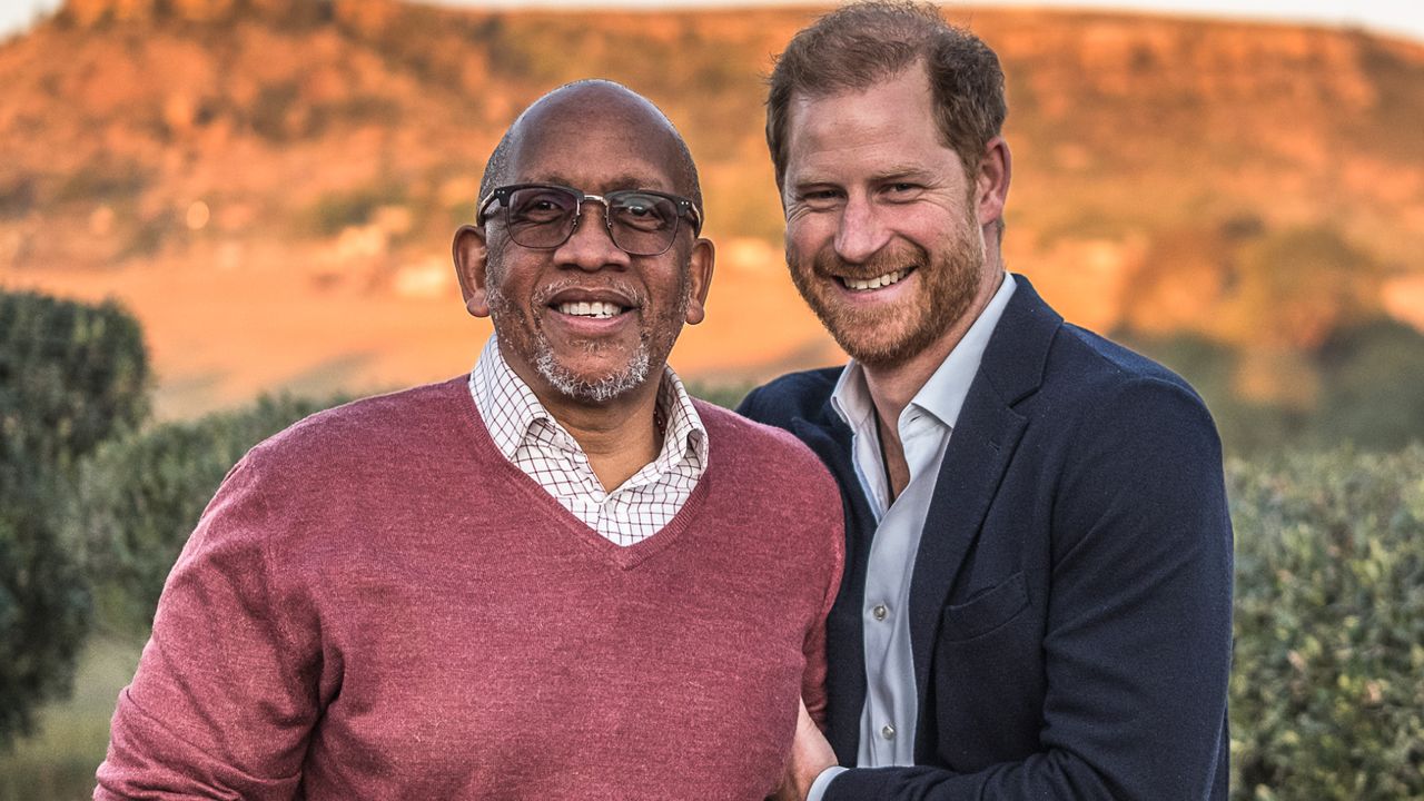 Prince Harry and Prince Seeiso of Lesotho standing in front of a mountain and smiling