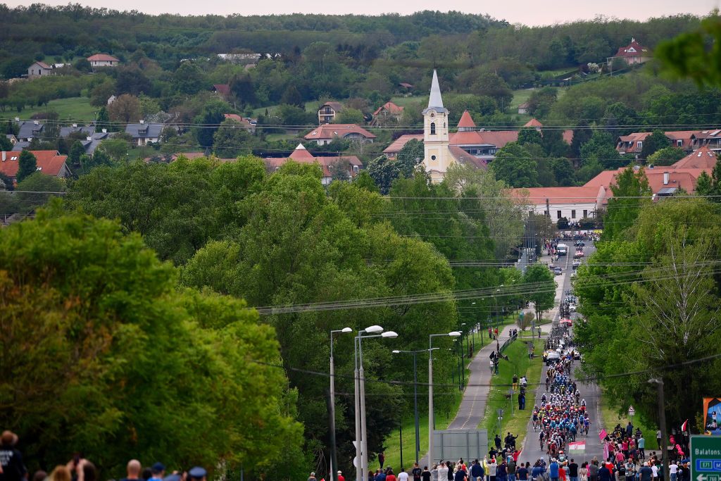 BALATONFURED HUNGARY MAY 08 A general view of the peloton passing through Eszterglyhorvti village landscape during the 105th Giro dItalia 2022 Stage 3 a 201km stage from Kaposvr to Balatonfred Giro WorldTour on May 08 2022 in Balatonfured Hungary Photo by Tim de WaeleGetty Images