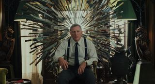 daniel craig as benoit blanc sitting on the knives chair in a still from Knives Out