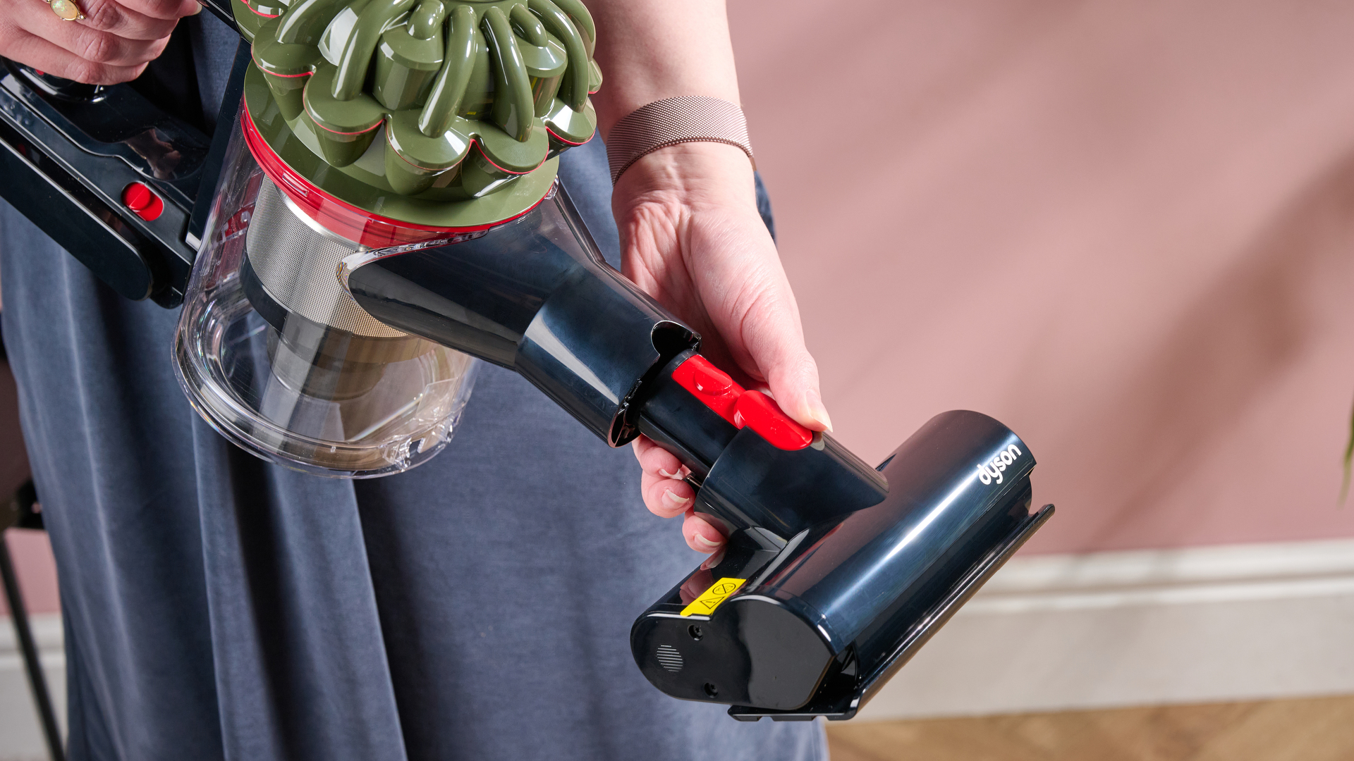Dyson V8 Cyclone with person showing how attachments can be removed