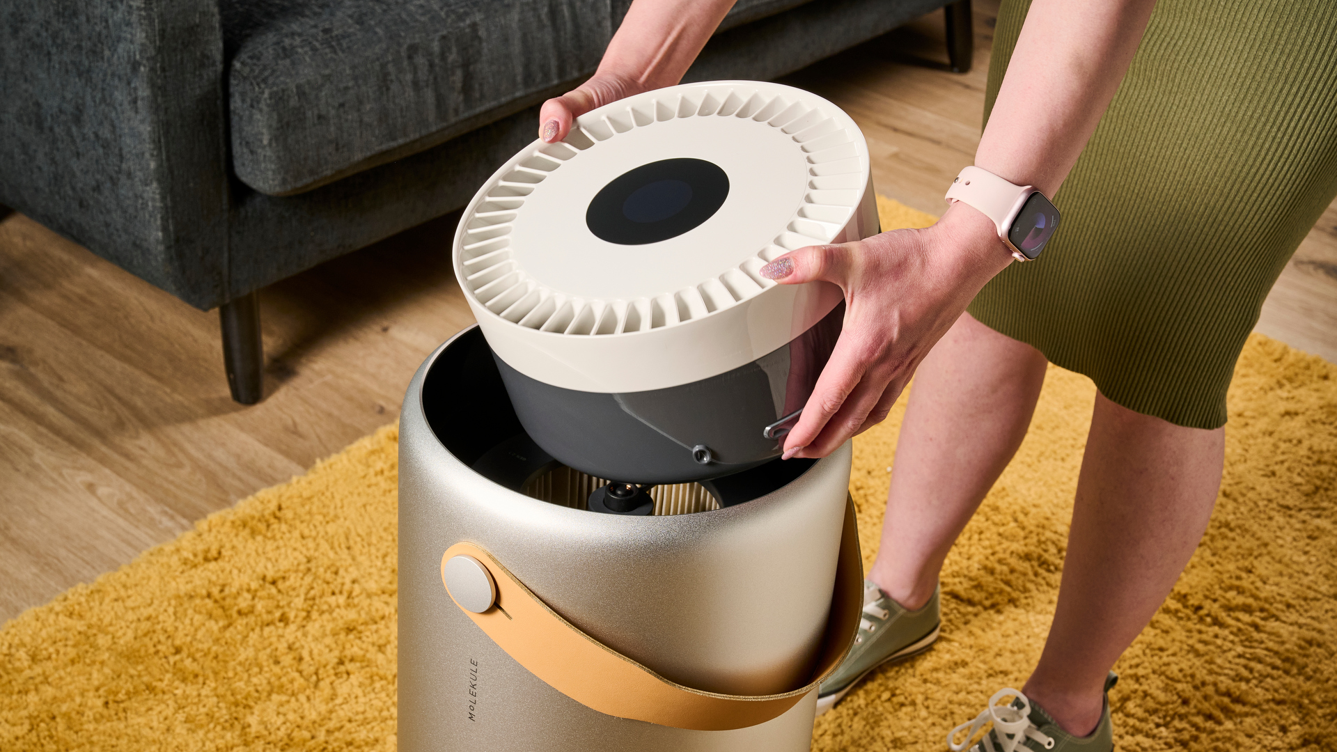 Image shows the top panel being lifted out of the Molekule Air Pro air purifier revealing the filter inside the base section.