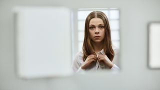 Stella (Alexandra Tyrefors) in custody as seen through a small gap for A Nearly Normal Family