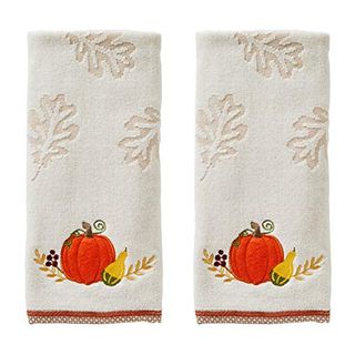 A set of two white cotton hand towels with embroidered pumpkin motifs