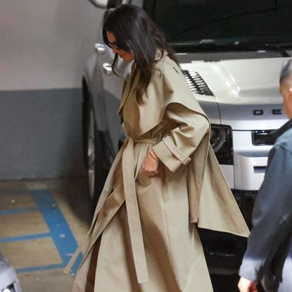 Kendall Jenner wearing a tan trench coat with black trousers and black pointed toe heels 