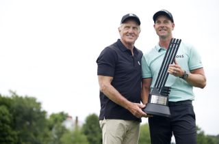 Norman and Stenson pose with a trophy