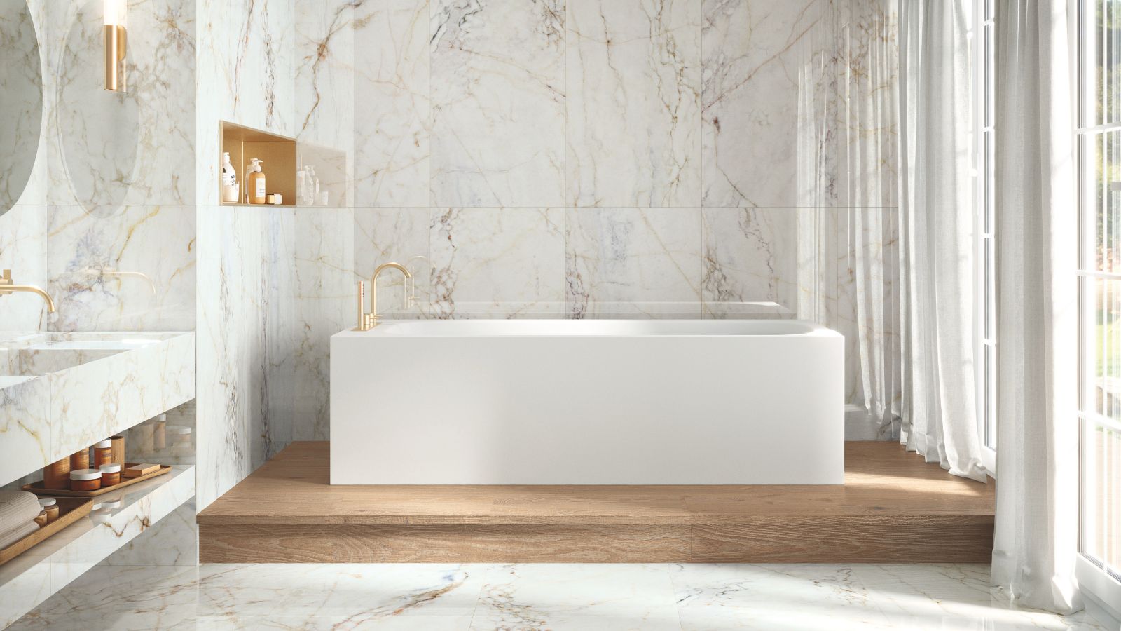 A serene luxury bathroom with a freestanding white bath, marble-effect walls, warm brass taps and soft natural light, creating a calm, hotel-style feel.