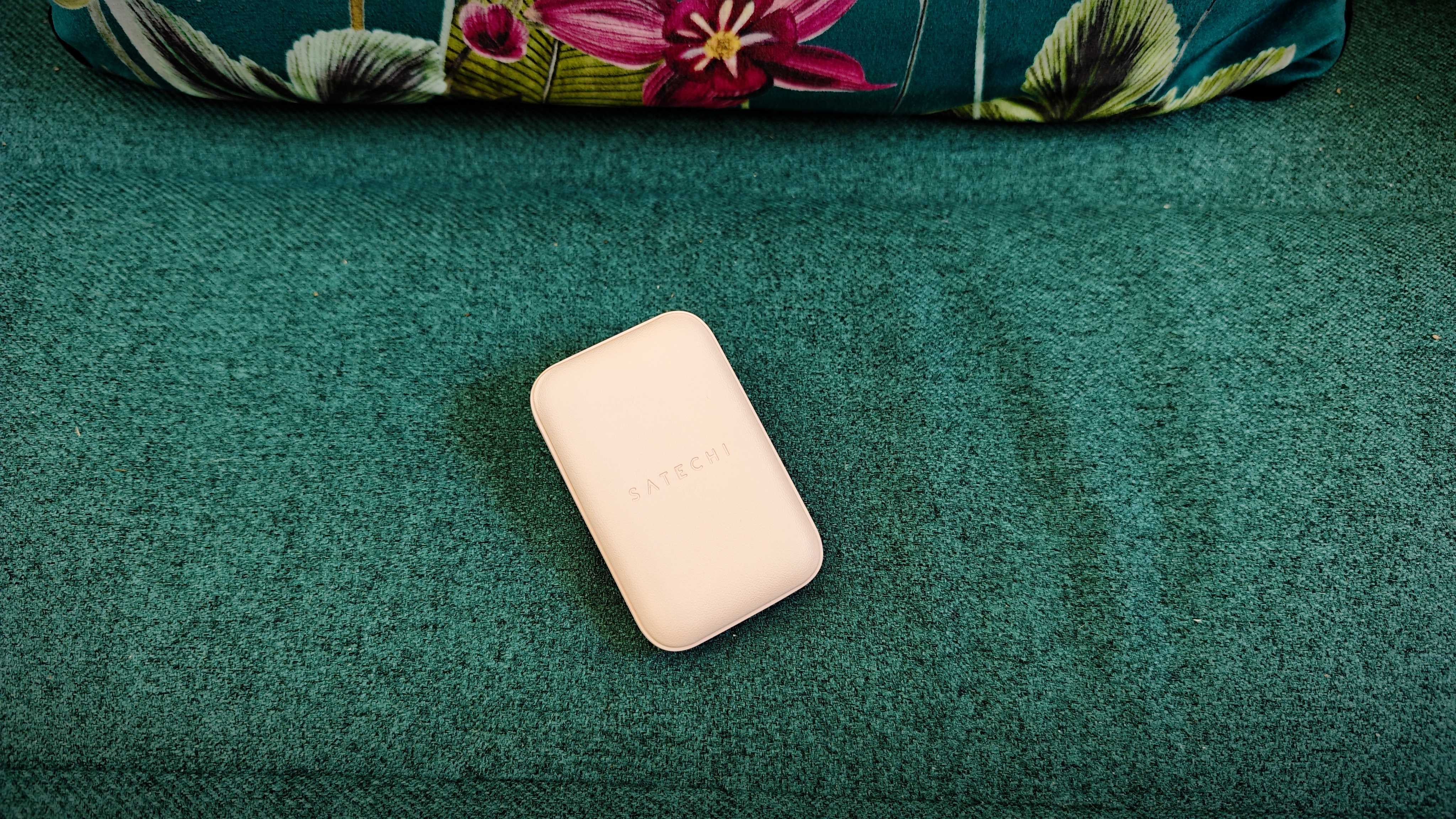 A Desert Rose coloured Satechi OntheGo 67W Slim Wall Charger on a green fabric sofa