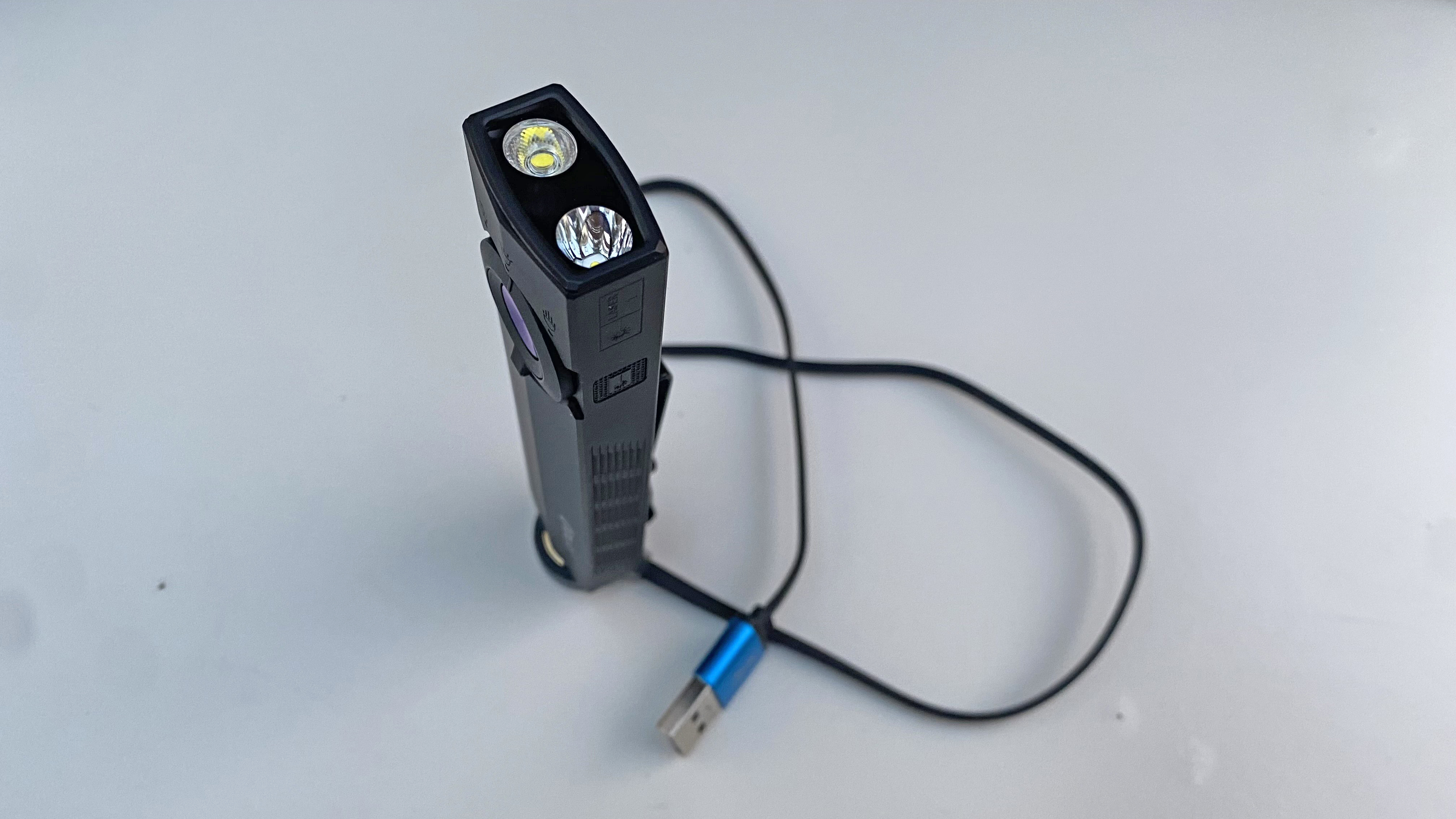 The Olight ArkPro shown on its charging dock