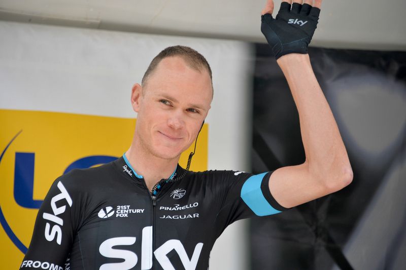 Chris Froome gives a wave after signing on