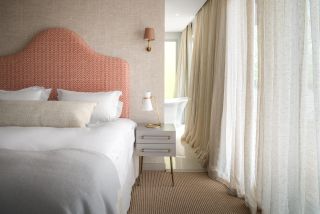 Small beige bedroom with orange headboard