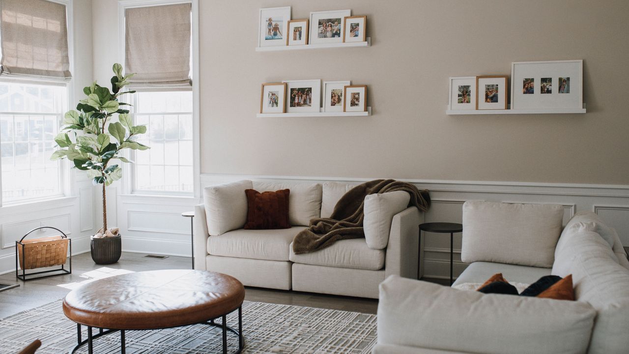 living room with pale plaster colored walls and white sofas with round coffee table