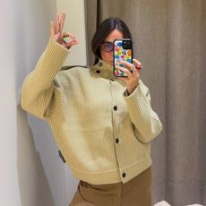 Woman wears mustard massimo dutti funnel neck button cardigan 