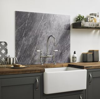 Grey marble backsplash in a kitchen with dark cabinets and Belfast/Butler's sink from British Ceramic Tile