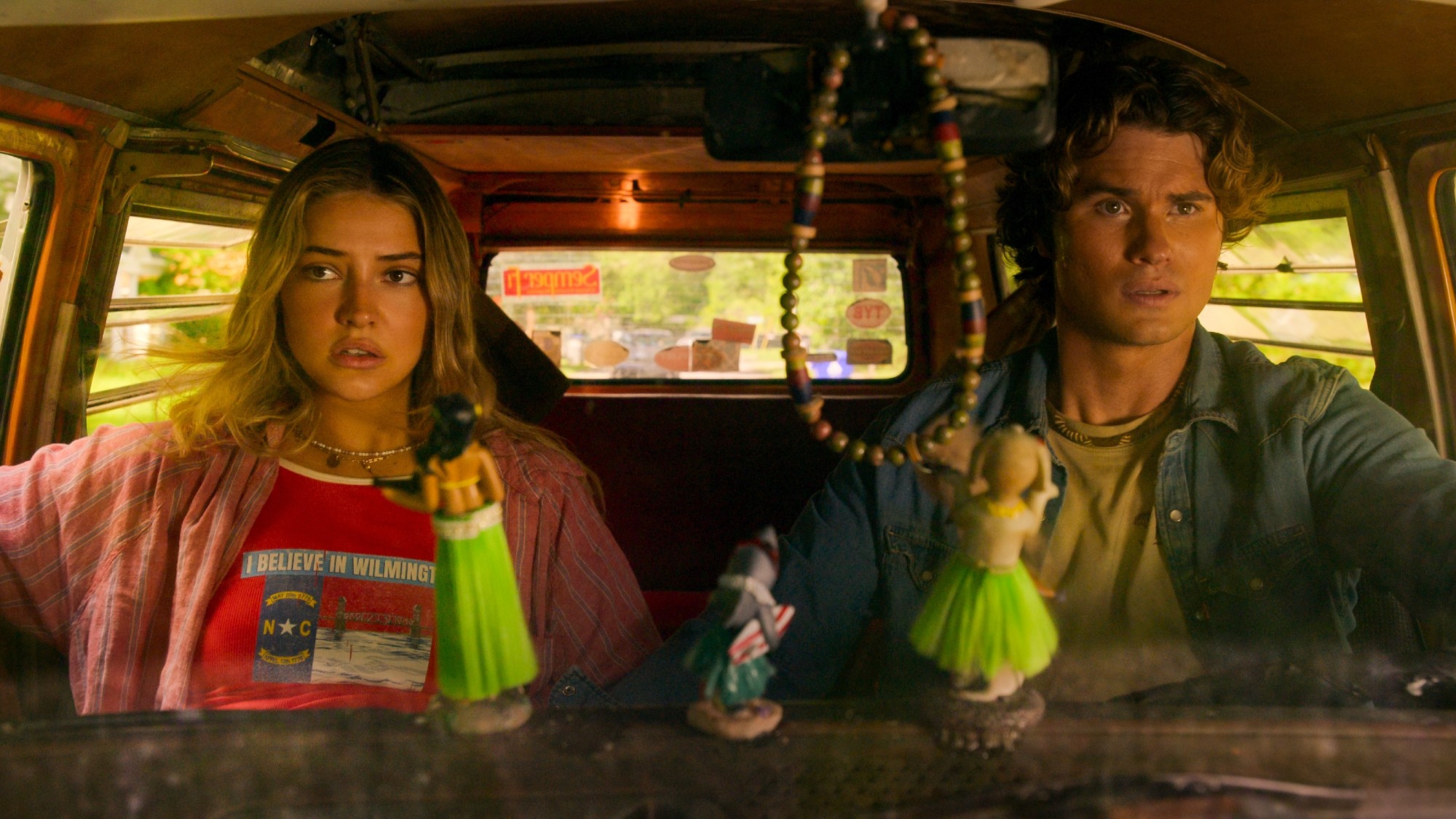Madelyn Cline as Sarah and Chase Stokes as John B. sitting in their van.