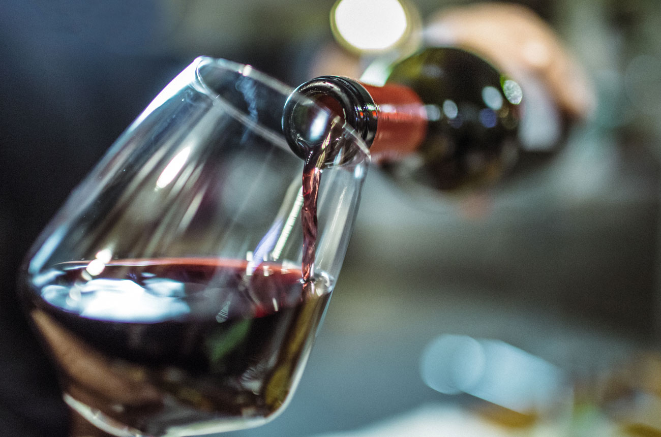Hand pouring red wine into a glass