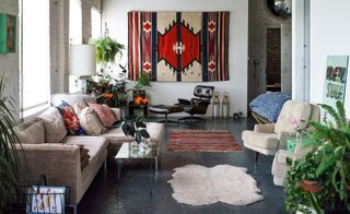 Living room with cream sofa and chairs and red geometric design rug on wall