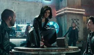 Alita: Battle Angel Alita crouched on a table in the Kansas bar