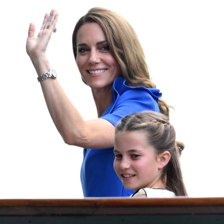 Princess Kate waves while wearing a royal blue dress while daughter Princess Charlotte wears white