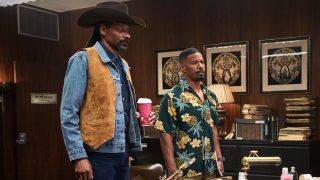 Snoop Dogg and Jamie Foxx standing next to each other in a cluttered office in Day Shift.