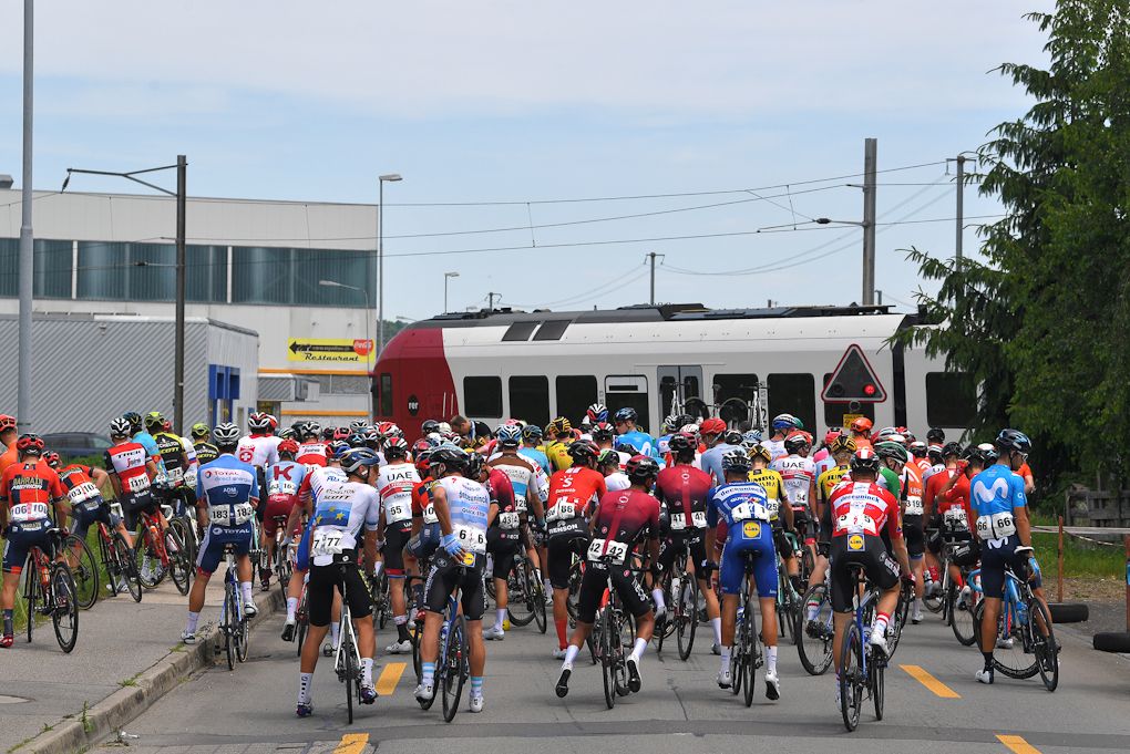 Riders are caught behind a train during stage 4 at Tour de Suisse