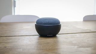 A Google Home Mini with a battery base on a kitchen table