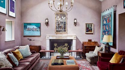 large pink living room with fireplace, rug and artwork