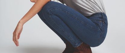 woman crouching wearing Wrangler jeans
