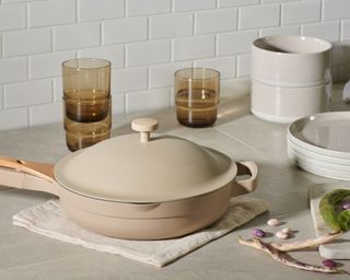 pale pink Always Pan from Our Place with amber glasses in neutral kitchen