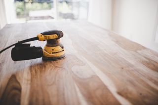 Electric sander on a wood table