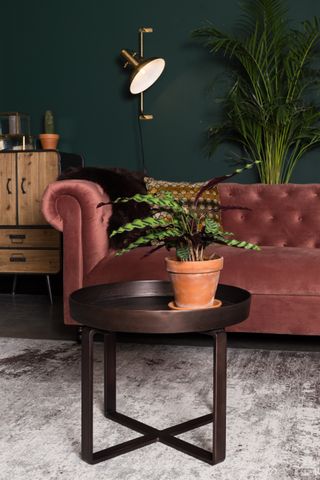 Blush-pink velvet sofa in a forest green statement living room