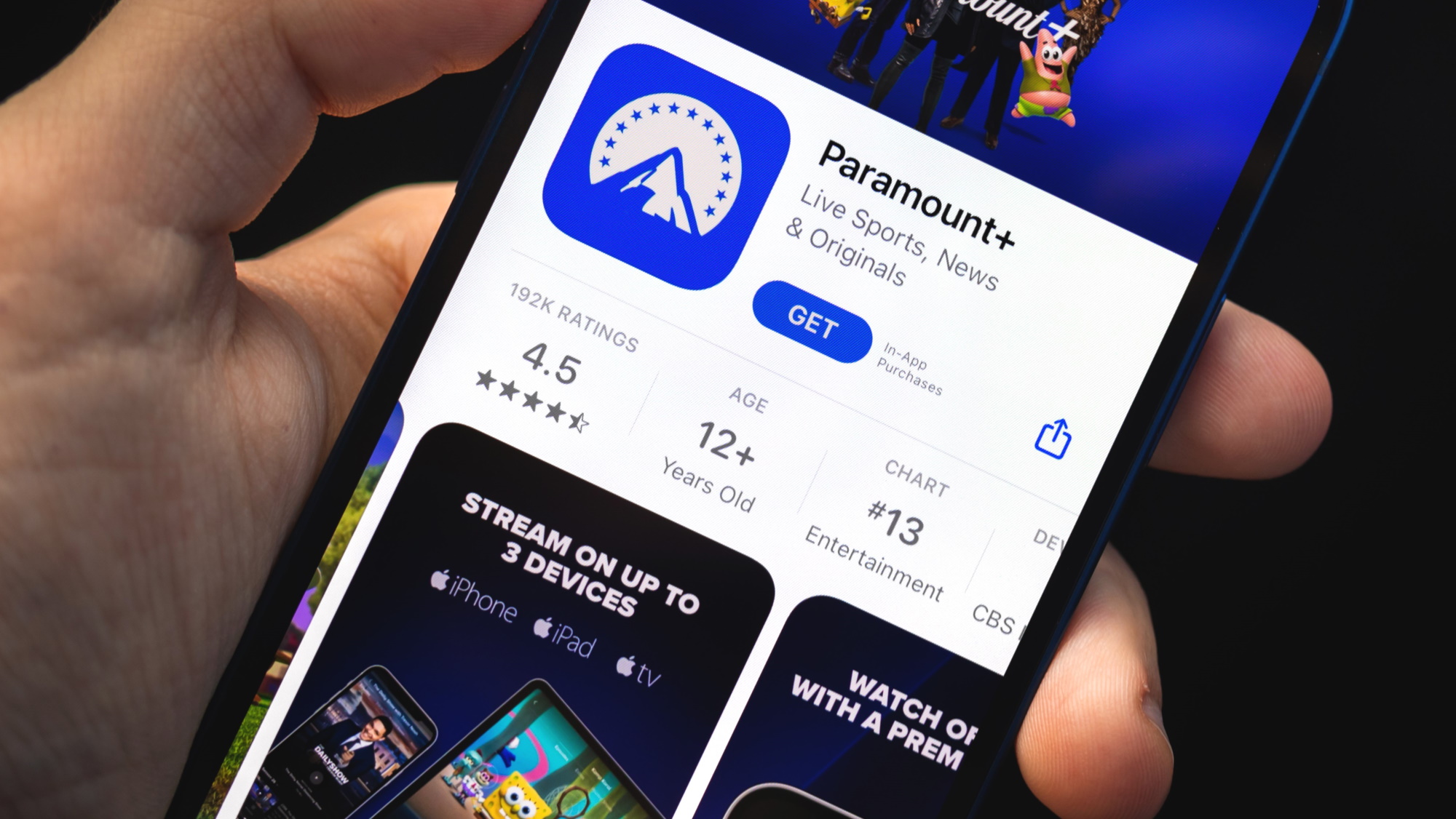 Hand holding smartphone with Paramount Plus App visible in the App Store