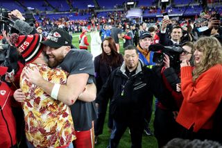 ravis Kelce #87 of the Kansas City Chiefs celebrates with his brother Jason Kelce as Taylor Swift looks on after a 17-10 victory against the Baltimore Ravens in the AFC Championship Game.