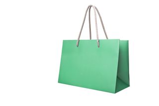 Green paper shopping bag isolated on white background