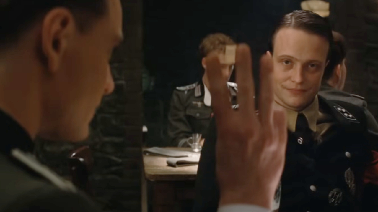 August Diehl as Major Hellstrom catching Michael Fassbender as Sgt. Hicox flashing the American Three in Inglourious Basterds