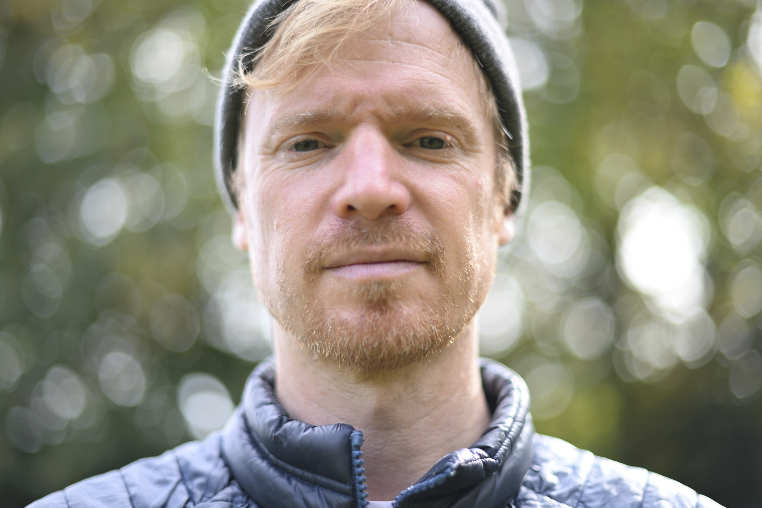 Head and shoulder portrait, outdoors, shallow depth of field, dappled light through tree leaves