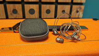 SoundMagic E80D and carry case resting on top of orange-colored amp
