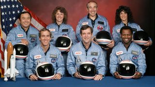 seven astronauts seated in two rows for a preflight picture