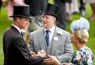 Prince William and Mike Tindall shake hands while wearing top hats