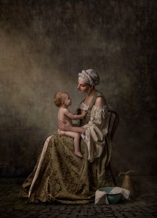 Woman sitting on chair with naked child