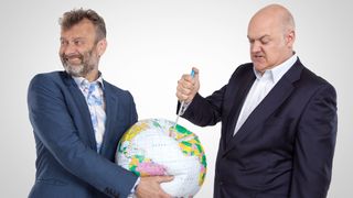 Mock the Week's Dara O Briain stabs a needle into a blow up globe held by fellow comedian Hugh Dennis.