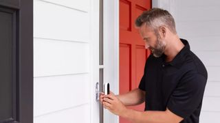 man fitting Google Nest Hello Doorbell to front of house