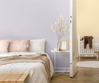 calming bedroom with lilac wall, doorway leading into pale yellow nursery room