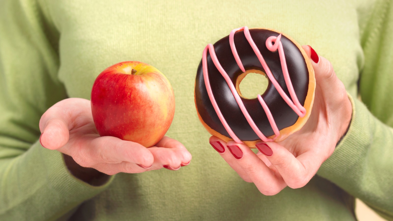 Hands holding apple and doughnut