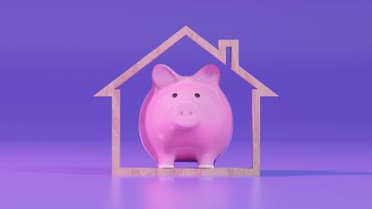 A piggy bank inside the frame of a house against a purple background.