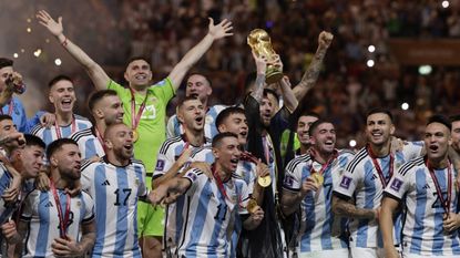 Lionel Messi lifts the 2022 World Cup trophy on behalf of his Argentina side, adorned in traditional Qatari attire