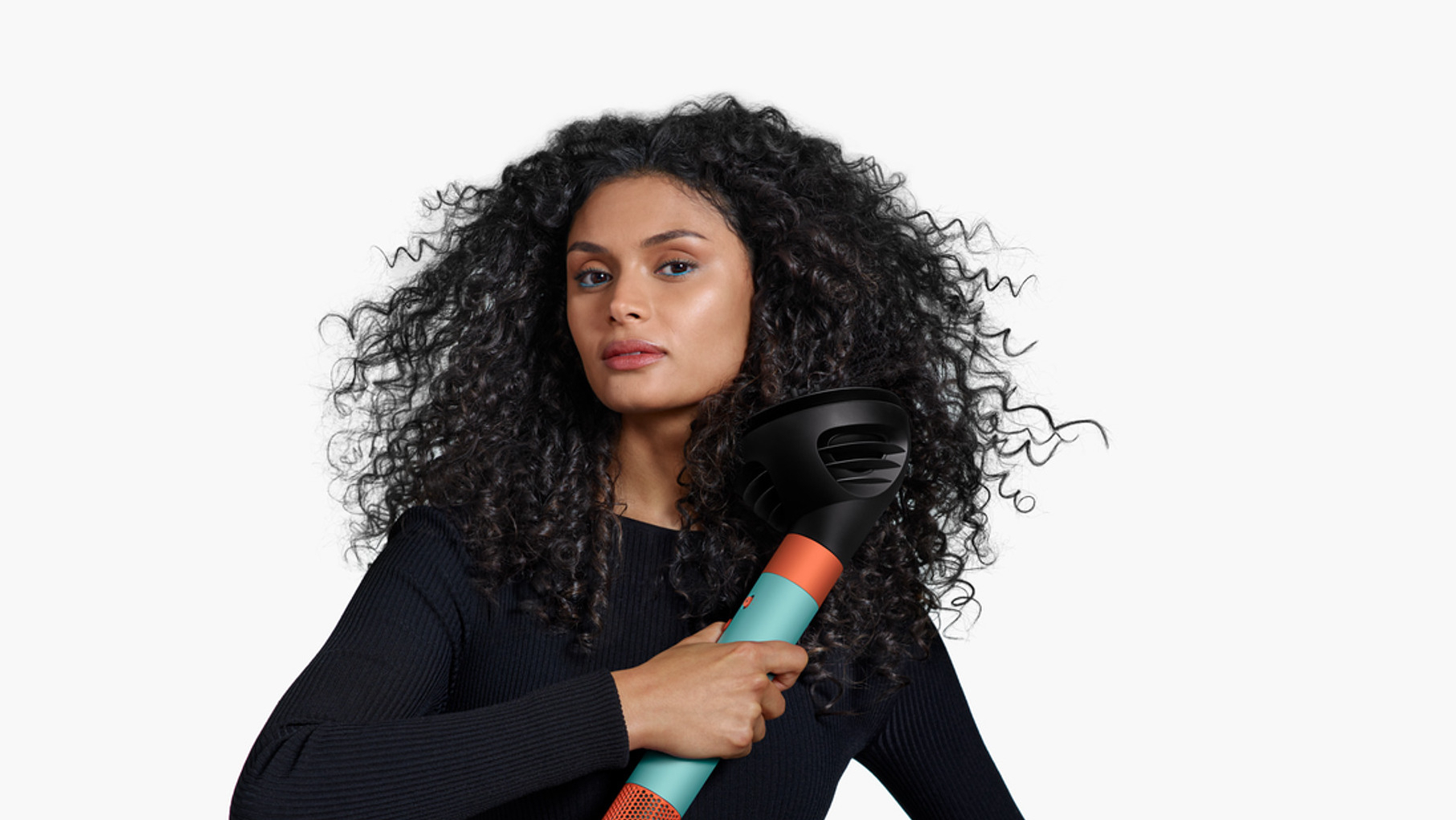 Woman using Dyson's Airwrap id with its Wave+Curl attachment