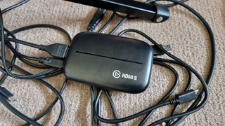 Elgato HD60S campture card sitting on a jumble of cables