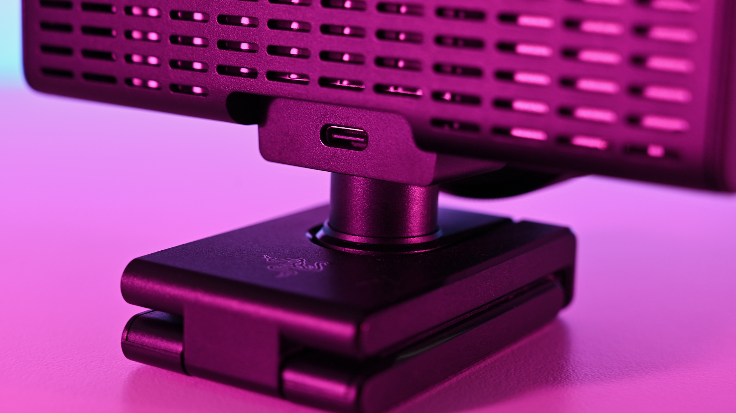 Close-up of the rear USB-C connection port and ventilation slots on the Razer Kiyo V2 Pro webcam under pink light