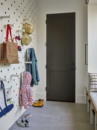 mudroom with pegboard storage system for kids